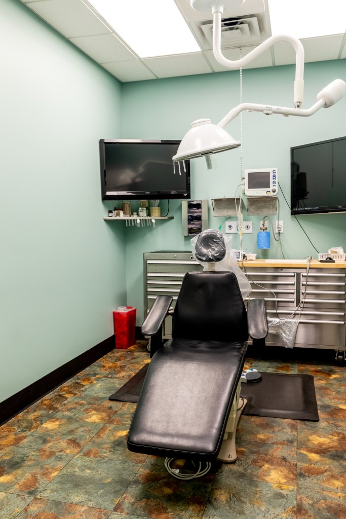 Small image of green patient room with chair and equipment.